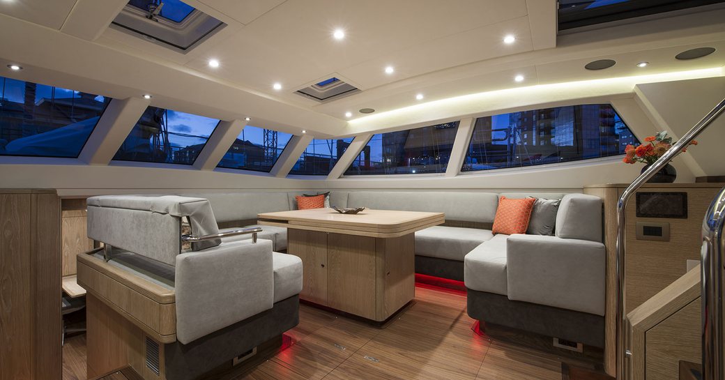 seating area with table in the main salon aboard superyacht FIREBIRD