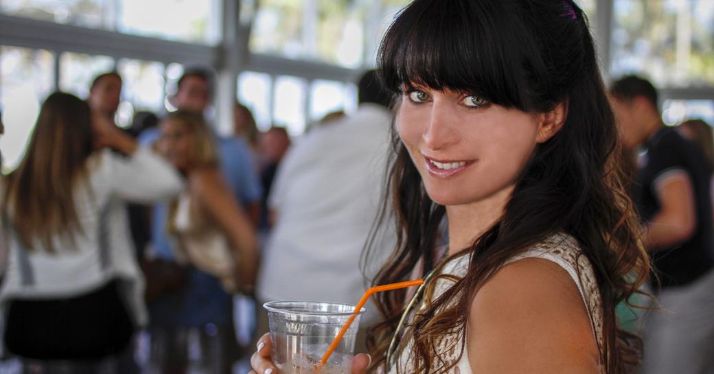 Woman holding drink at Windward VIP lounge at Palm Beach Boat Show