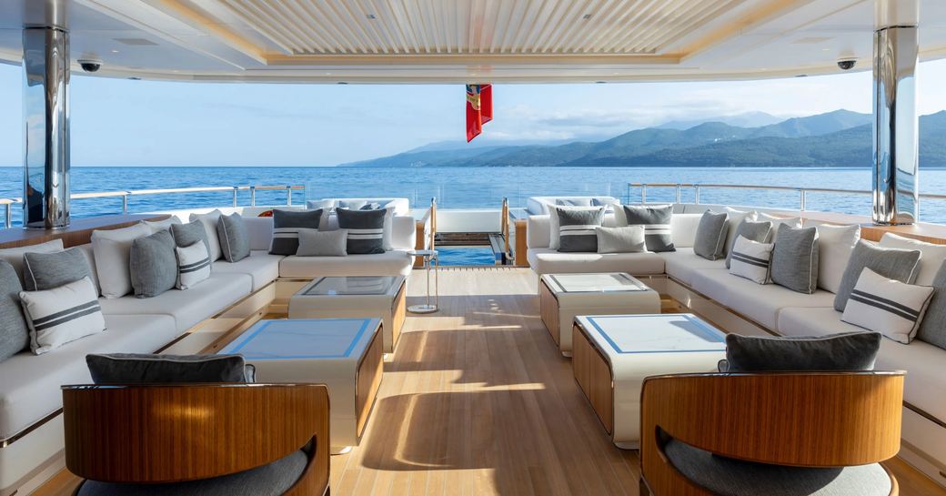 Overview of charter yacht ALCHEMY aft deck, exterior lounge area surrounded by views of the sea