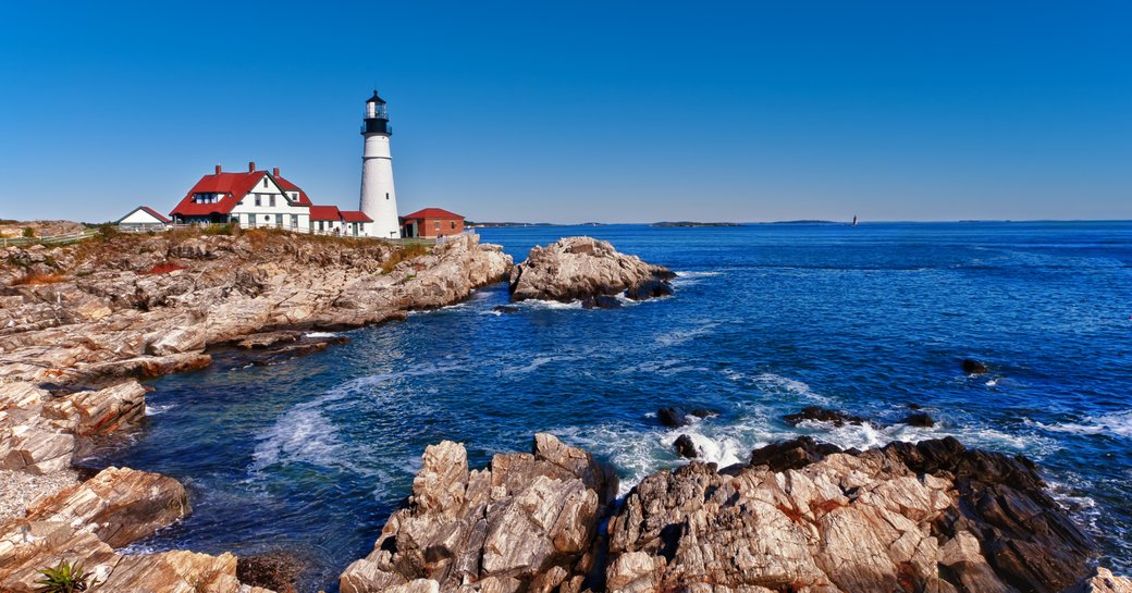 A lighthouse perched on the rocks along the Maine coastline