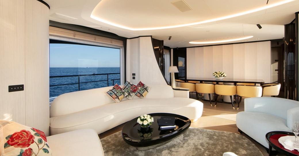 sofa and dining table in the main salon aboard charter yacht URIAMIR 