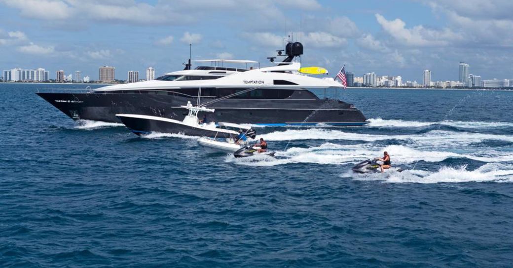 A running shot of motor yacht TEMPTATION with a selection of waverunners and extended tenders