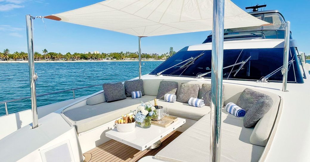 Overview of the foredeck onboard charter yacht C-DAZE, spacious seating that doubles as sunpads with a bimini