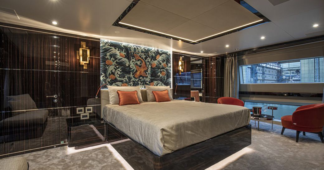 master cabin on luxury yacht happy me, with large bed, wood panelling and discreet lighting 
