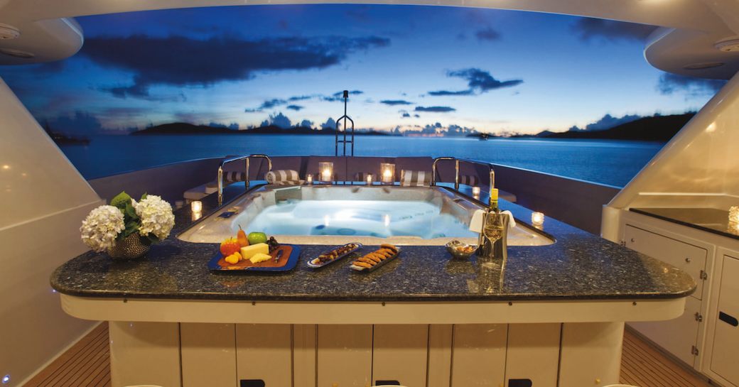 Jacuzzi on the sundeck of superyacht Milk and Honey lit up at night