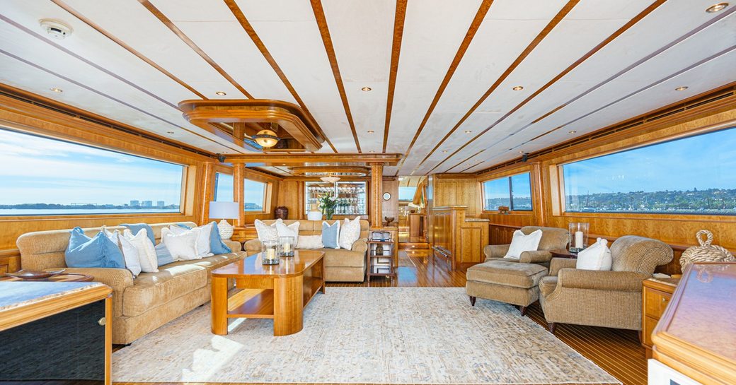 Overview of the main salon onboard charter yacht ALMOST THERE, featuring an extensive lounge area and wide windows to port and starboard 