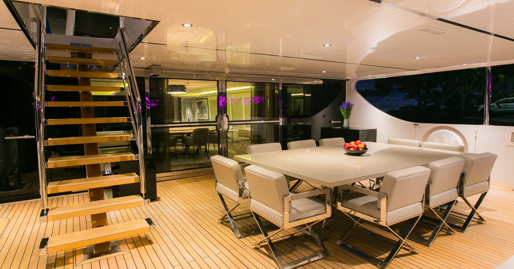 square alfresco dining table on aft deck of charter yacht SAHANA 