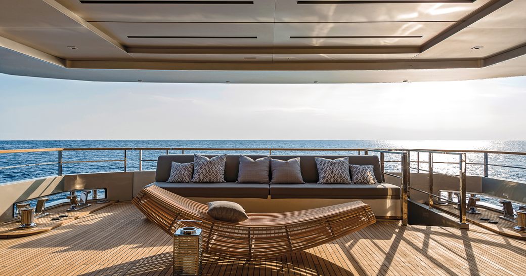seating area on aft deck of superyacht giraud with views over mediterranean in background