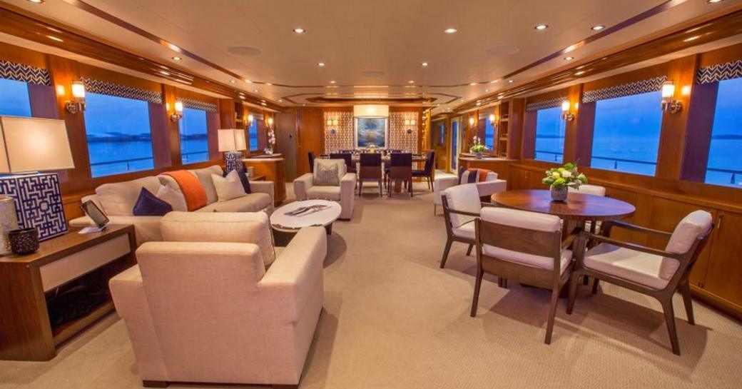 sumptuous lounge in main salon of luxury yacht ‘Far Niente’ with dining area in background