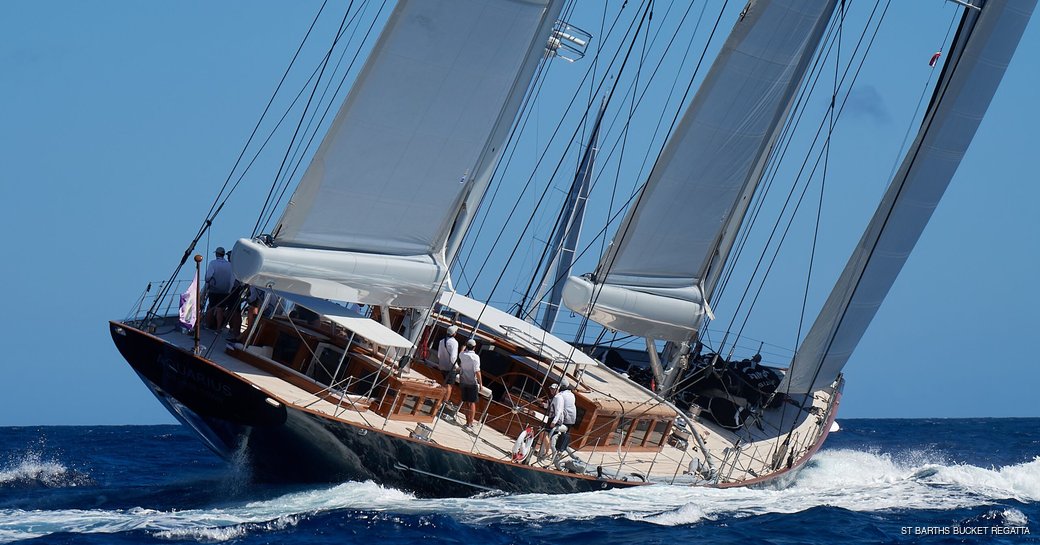 Charter yacht competing in St Barths Bucket Regatta, with sailors on yacht as she turns