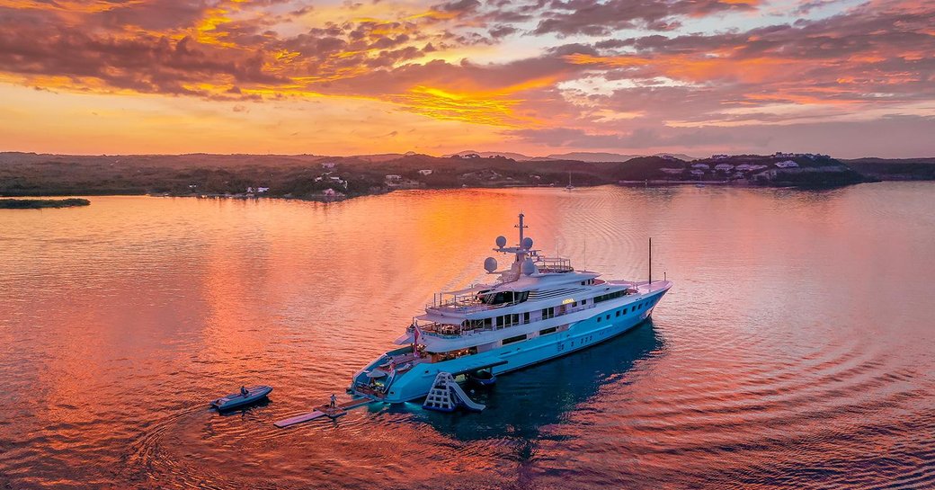 Superyacht AXIOMA on the water at sunset with tender behind