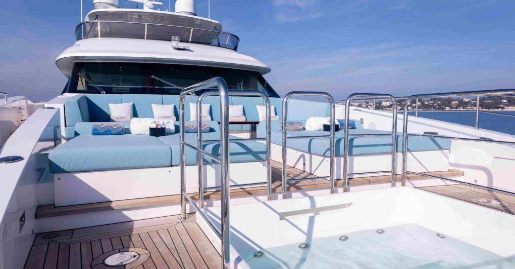 Sundeck onboard boat charter CHARADE with blue seating and a deck Jacuzzi