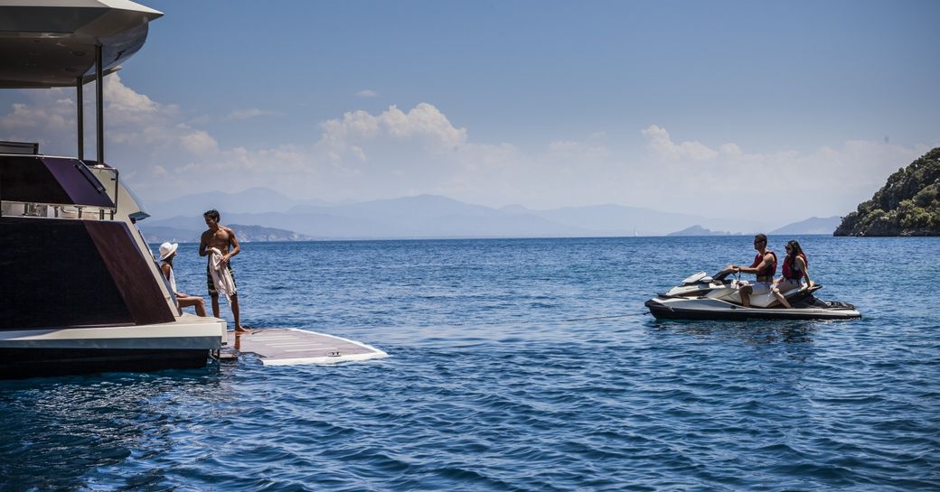 luxury yacht swim platform with jet skis approaching