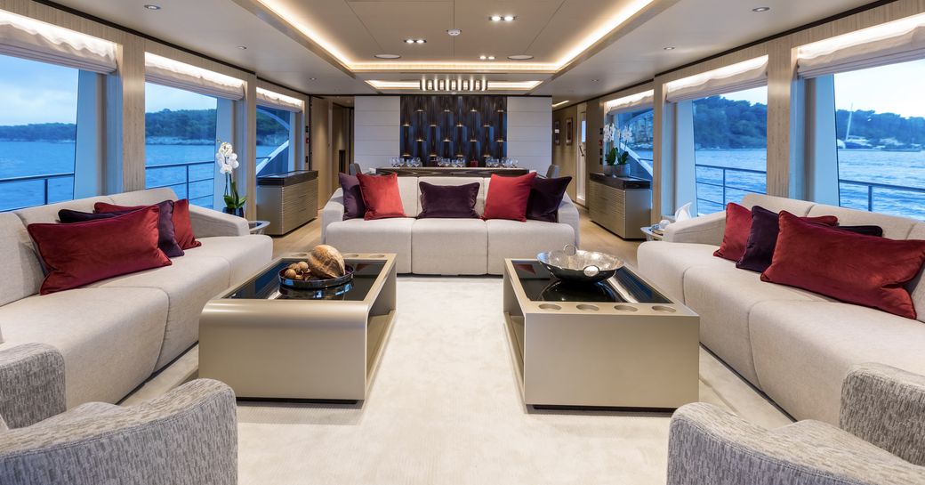 main salon seating area flanked by huge windows on board superyacht ONEWORLD 