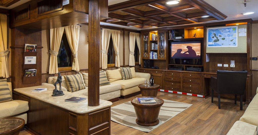 L-shaped sofa faces TV in the timelessly styled main salon aboard charter yacht GRACE 