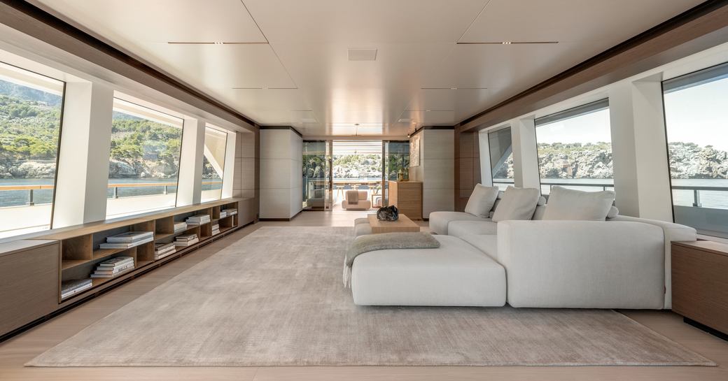 Interior of SANGHA superyacht with light colored furnishings, large sofas and expansive windows