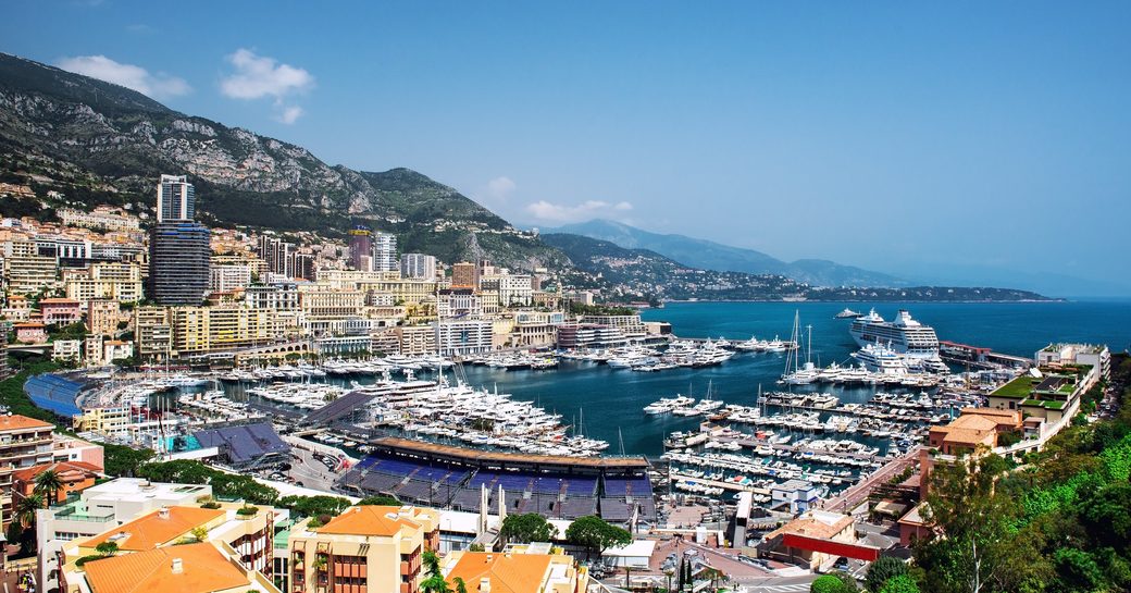 Overview of Port Hercule adjacent to Monte Carlo F1 track. Many motor yachts berthed.