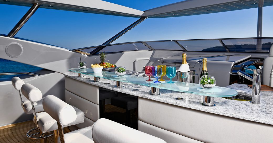 Bar on flybridge deck with stools and drinks