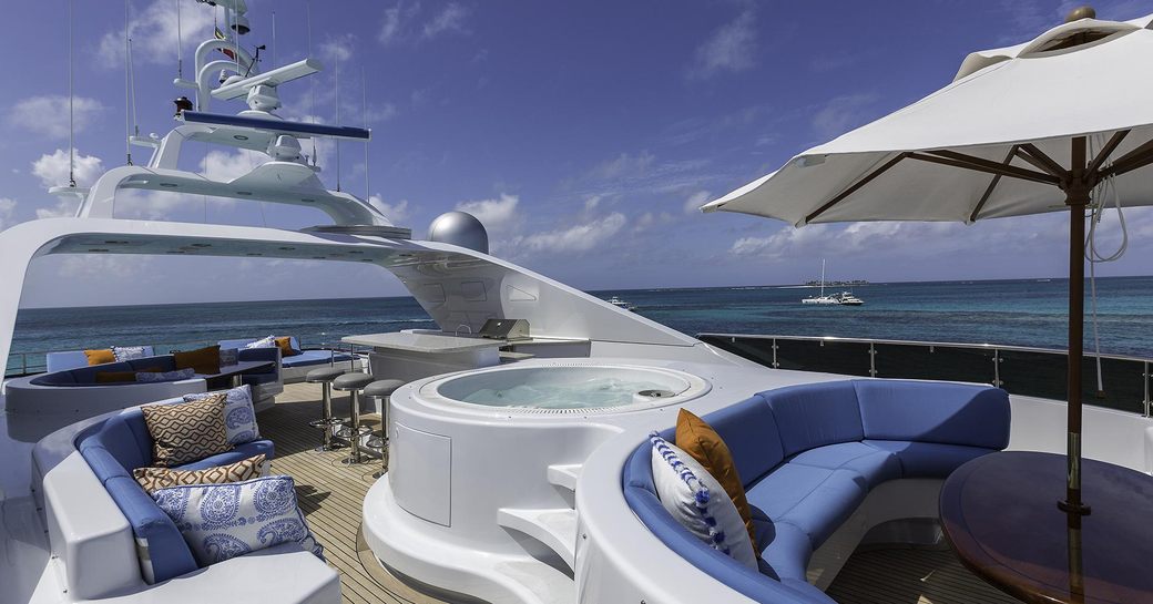 Sundeck on superyacht M3, with jacuzzi pool and a number of seating areas and wet bar in background
