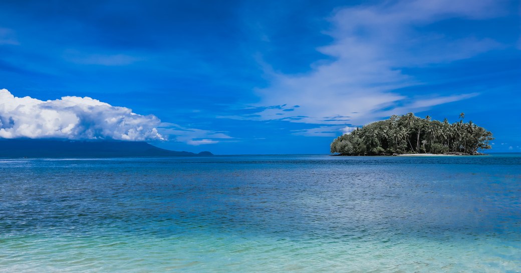Bismarck Sea with deserted tropical island and clear blue waters in Papua New Guinea. Madang
