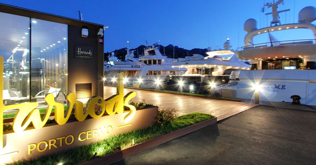 A harrods sign with yachts located in the background