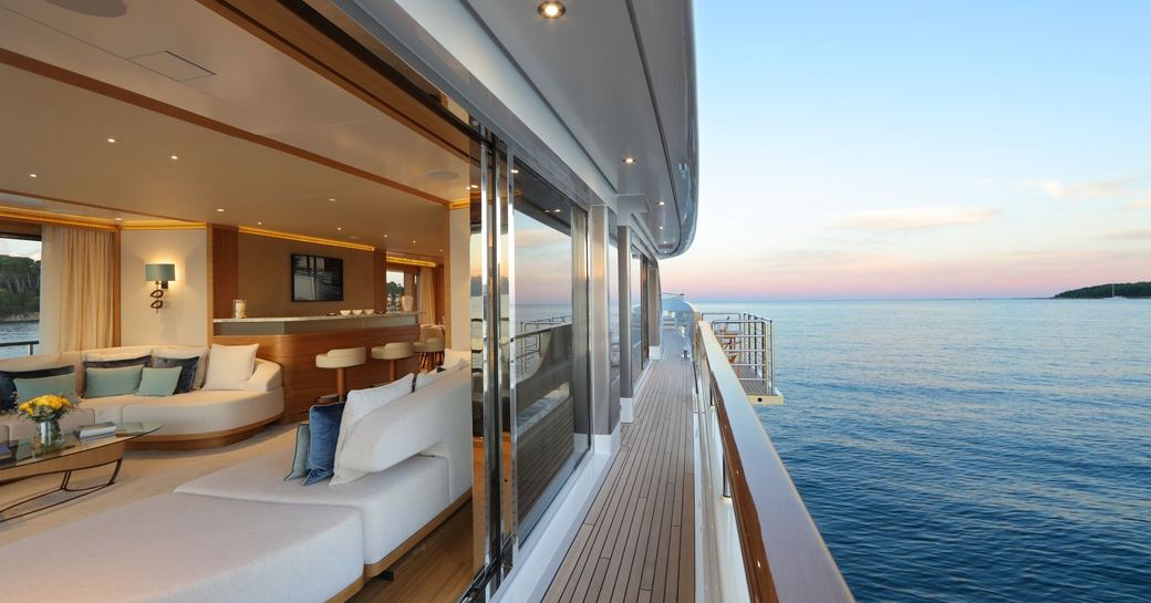 side deck with view into main salon as the sun sets aboard charter yacht SOLIS 