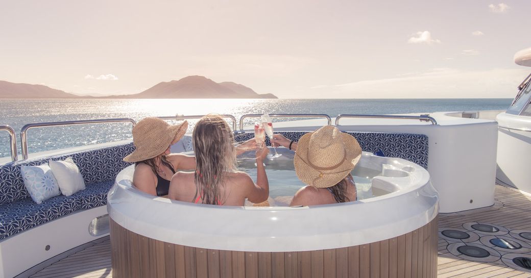 guests sip champagne in the Jacuzzi aboard motor yacht SPIRIT