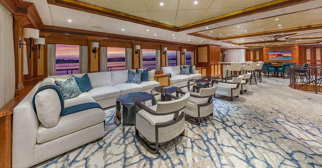 Main salon onboard charter yacht UNBRIDLED, lounge area in foreground wth dining area in the background