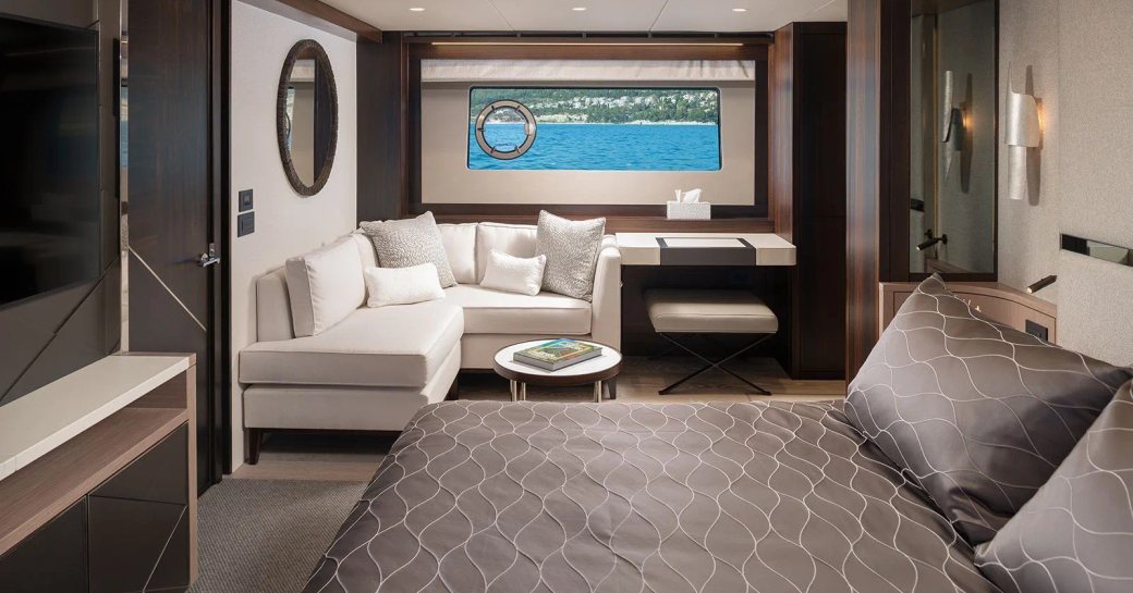 Master cabin onboard charter yacht MOWANA, with berth in the foreground and a generous seating area in the background