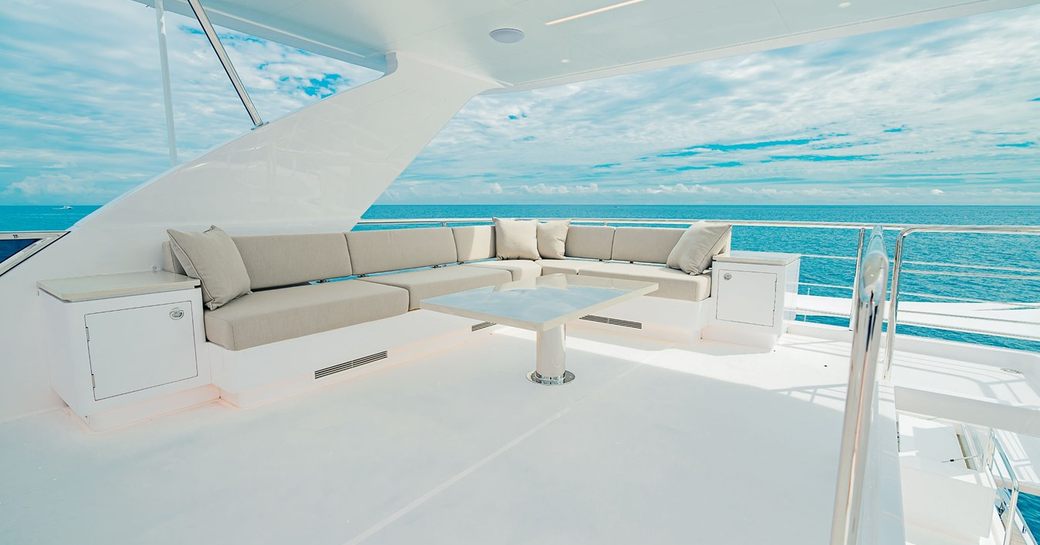 Sun deck onboard luxury yacht rental SEA-RENITY, with corner seating and views of the sea