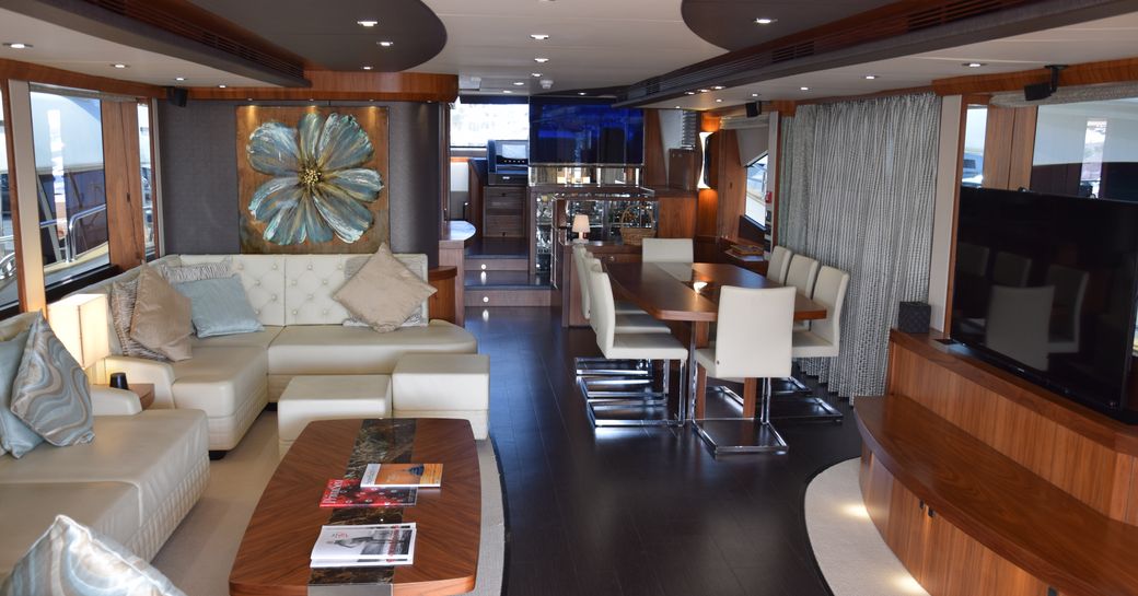 Main salon of luxury yacht Ray III, with lounging area, TV and dining 