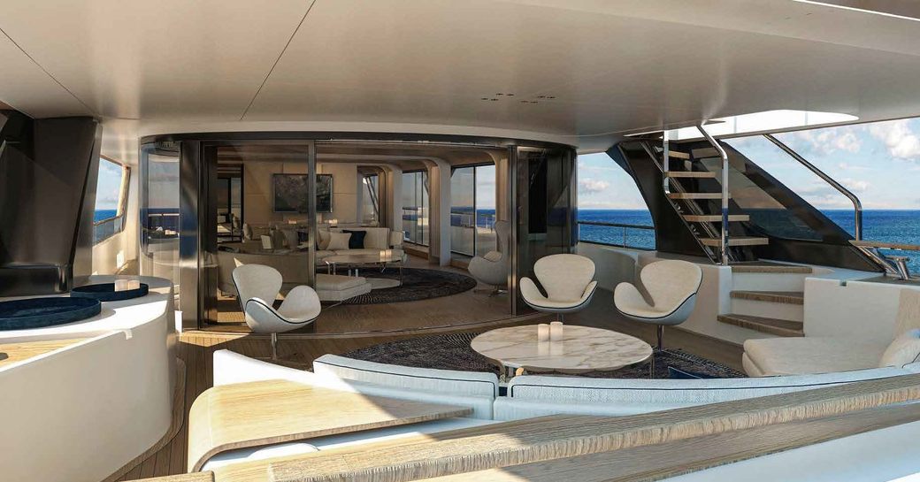 Overview of the main deck onboard charter yacht ALLURIA, with exterior seating area in the foreground and interior lounge visible in the background