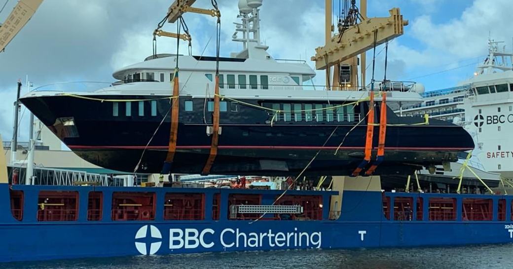 Superyacht Ice 5 is hoisted onto cargo vessel to begin journey to refit yard 