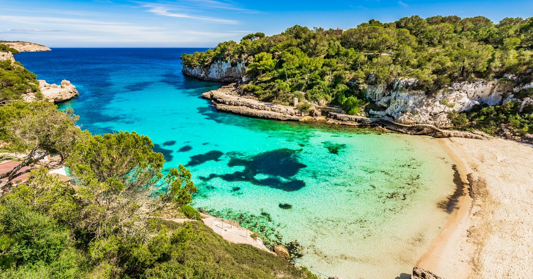 White sand beach in Mallorca, with turquoise water in bay