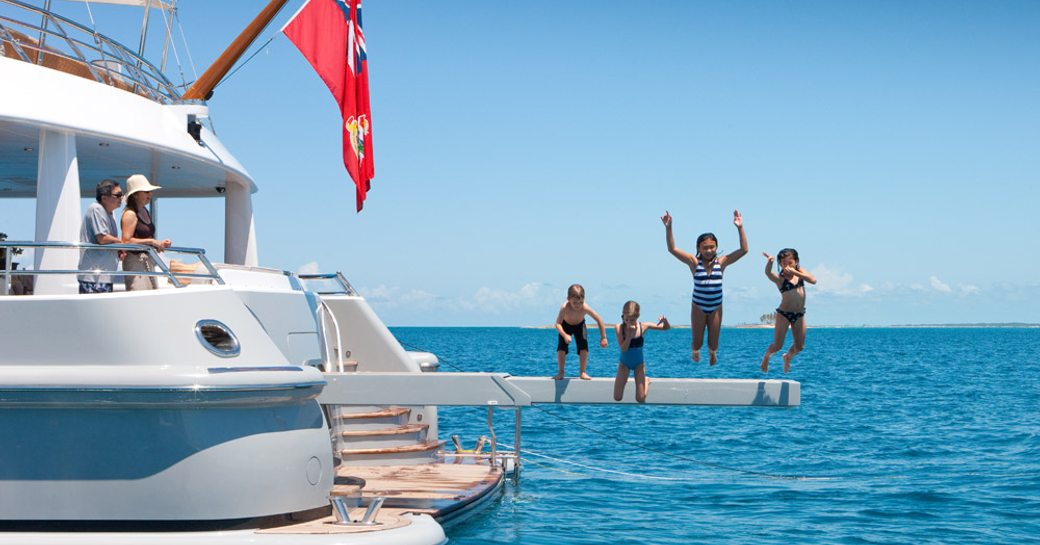 guests jumping from swim ramp of superyacht APRIL