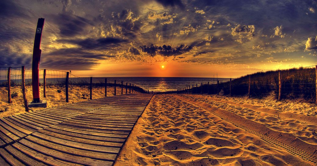 sun sets over golden sand beach in Ibiza