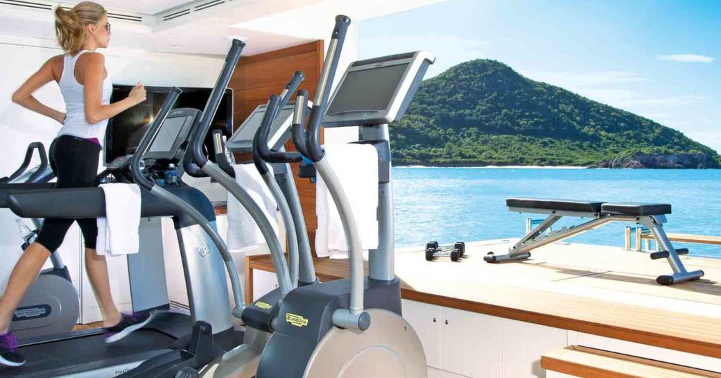 A woman uses a treadmill on a yacht