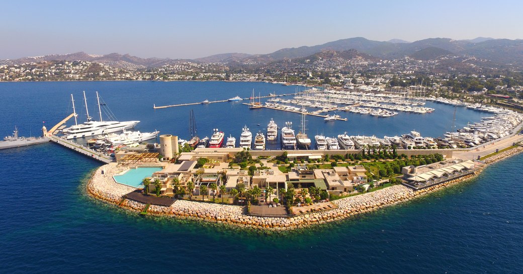 Aerial view of a Turkish marina with multiple luxury yacht charters berthed
