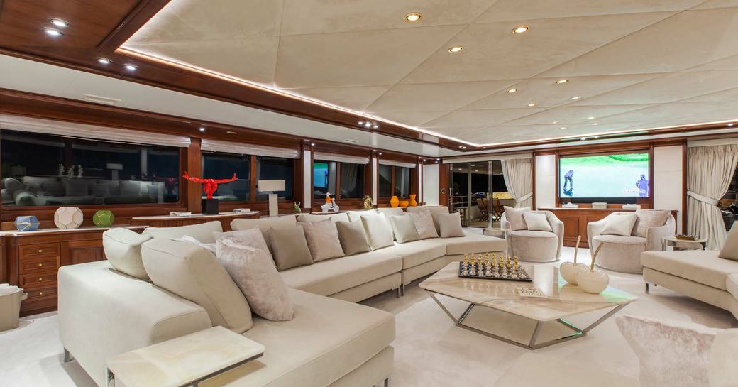 the expansive and airy upper lounge on charter yacht o'mega sitted with home cinema system and grand piano