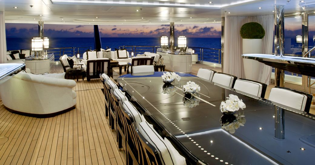 winter garden with long dining table on the upper deck aft of superyacht Phoenix 2