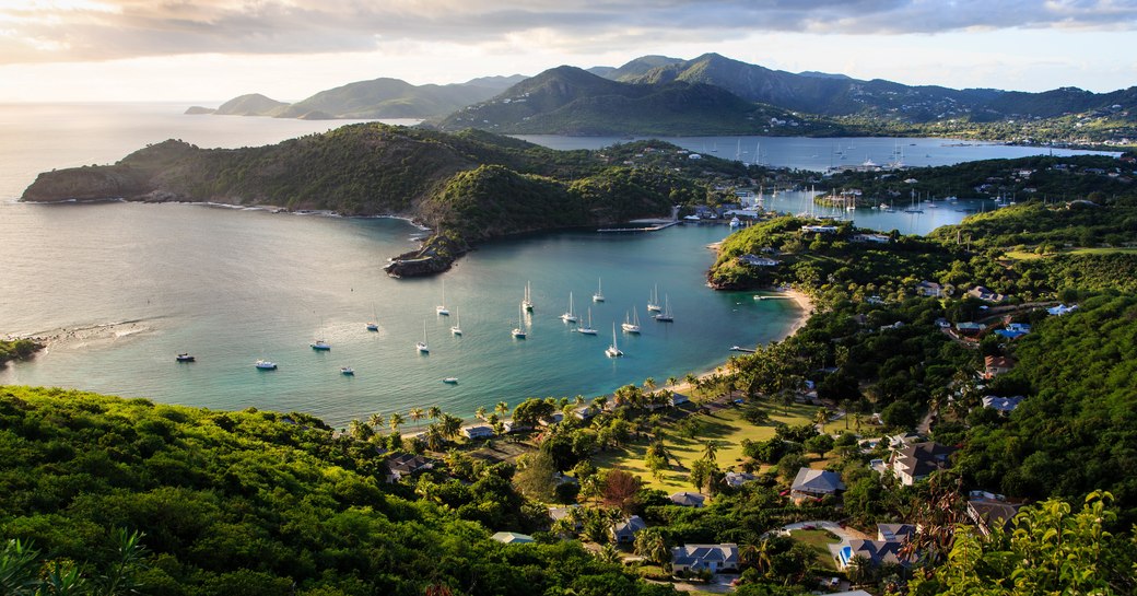 Antigua as seen from above with yachts in the water of bay and lush landscapes