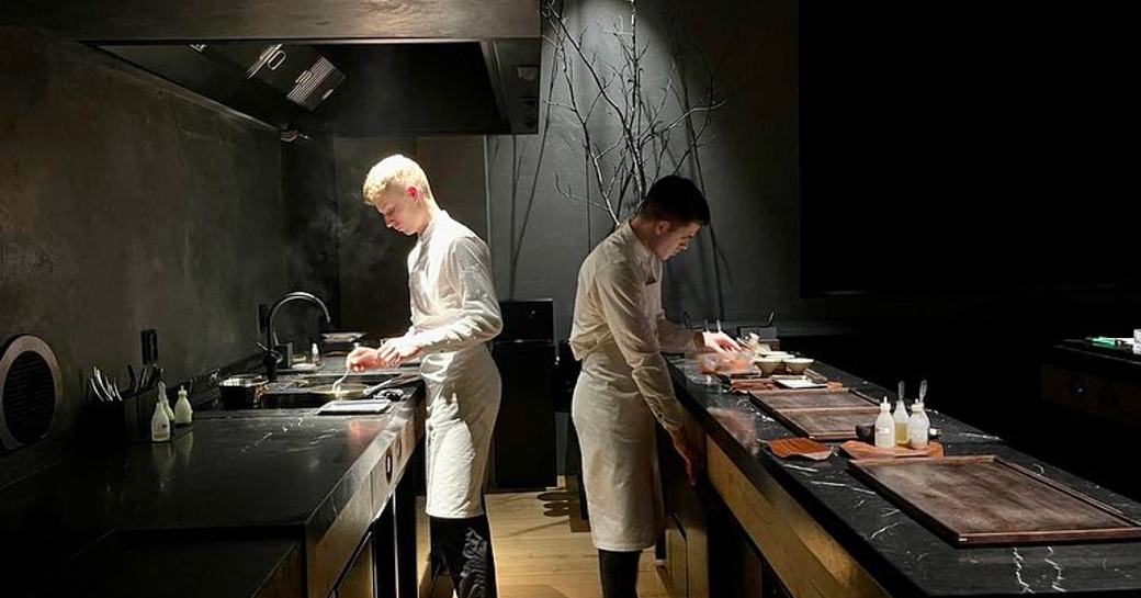 two chefs at work in the open kitchen in maaemo michelin star restaurant, oslo, norway