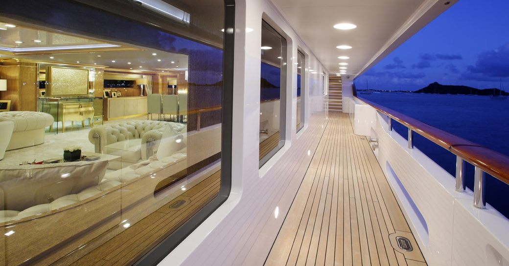 side deck with view into main salon at night on board luxury yacht ‘Lady Luck’ 
