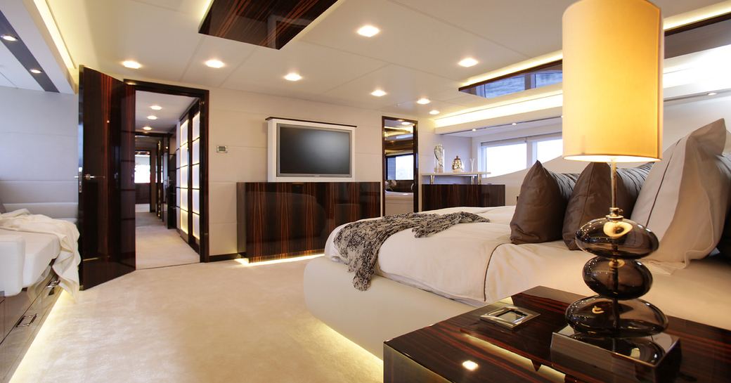Master stateroom on superyacht GEMS II, with light design and wooden effect furnishing