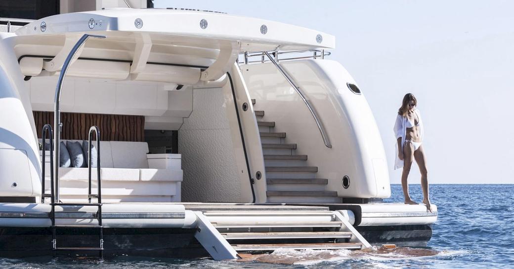 charter guest stands on the edge of the swim platform on board superyacht RUYA 