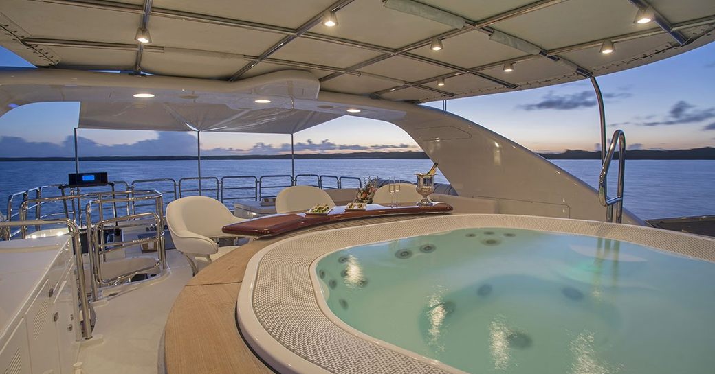 sundeck on luxury yacht pure bliss, with jacuzzi in foreground and swim-up bar in background