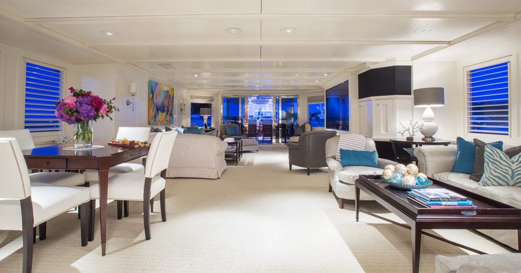 games table and sofa in light and airy skylounge of charter yacht RHINO 