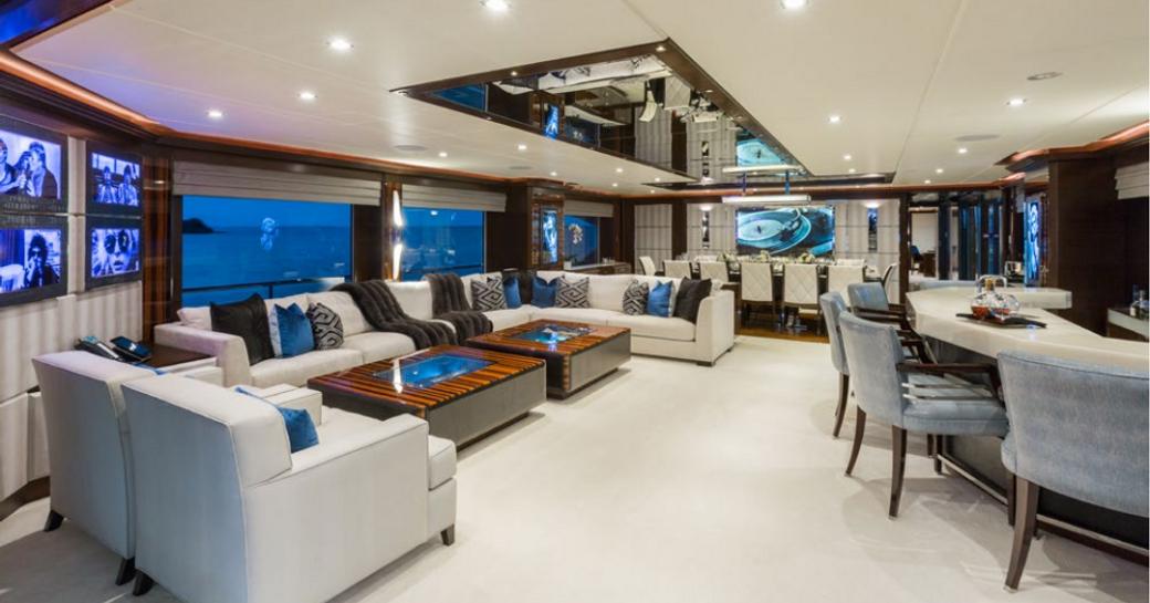 plush main salon with large lounge, bar and dining area, and rock 'n' roll photography collection aboard motor yacht ‘King Baby’ 