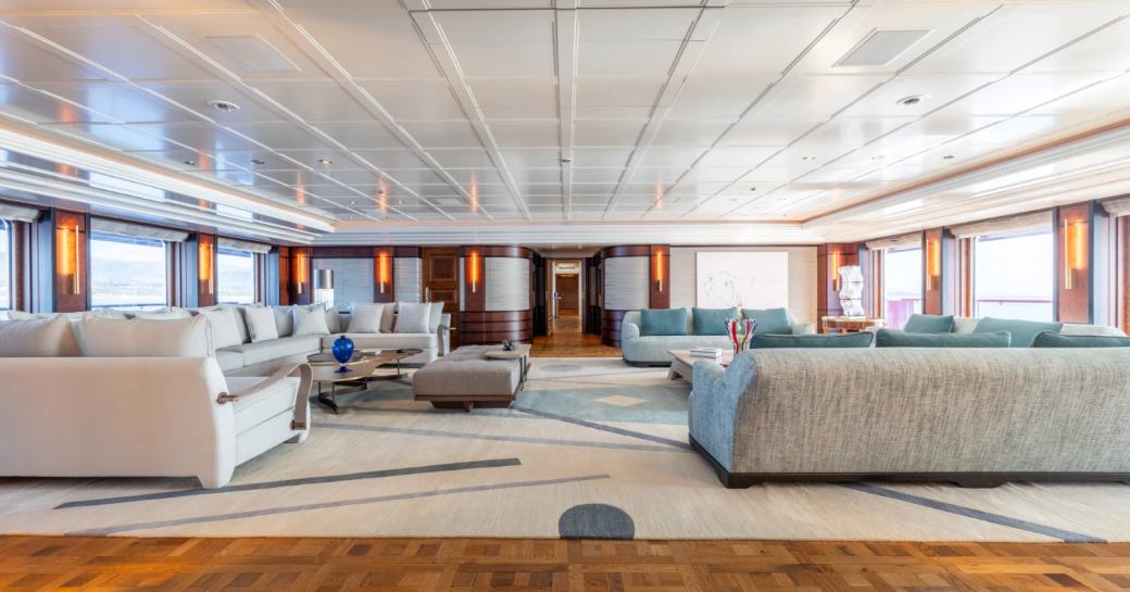 Main salon onboard charter yacht CARINTHIA VII, extensive lounge area with plush white and gray seating