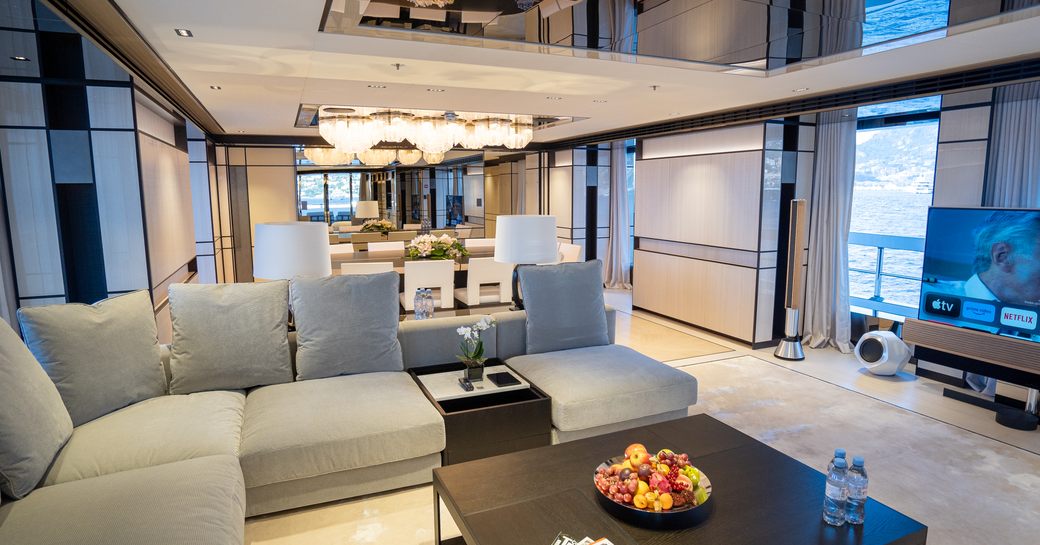 Overview of the main salon onboard charter yacht RELIANCE, lounge area in foreground with dining area aft.